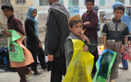 Afghan children sell plastic bags at a market in Kabul
