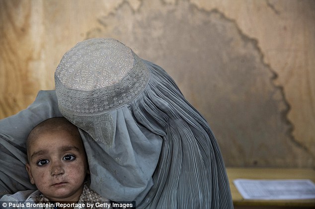 An Afghan mother holds her son, who is being treated for malnutrition