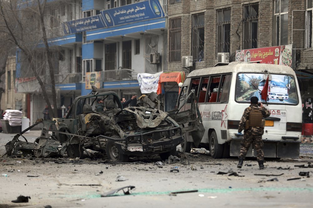 Afghan security personnel inspect the site of a bomb attack in Kabul, Afghanistan, Saturday, Dec. 26, 2020