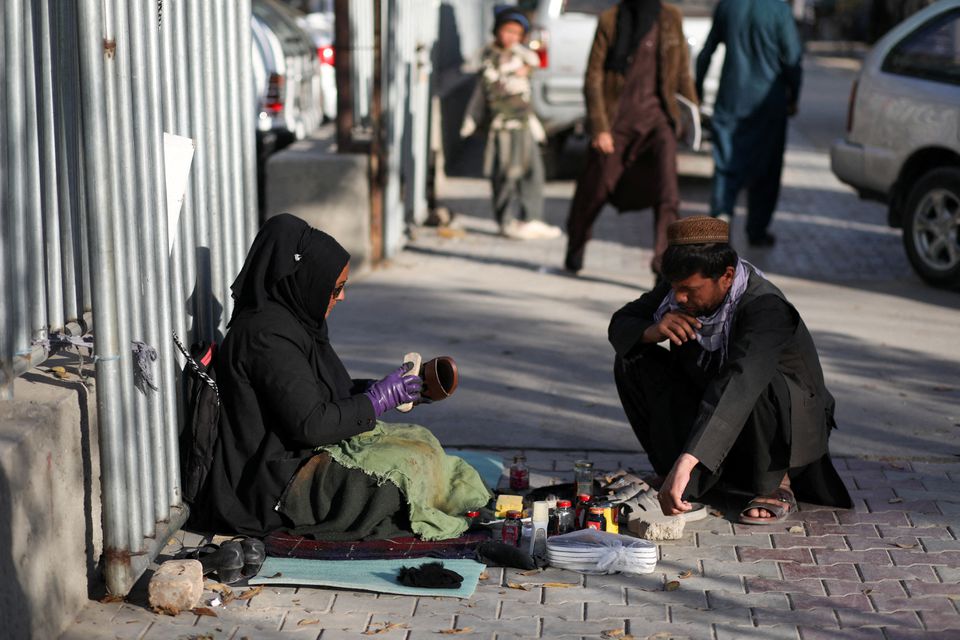 Hadia Ahmadi a teacher in Kabul earns by polishing shoes