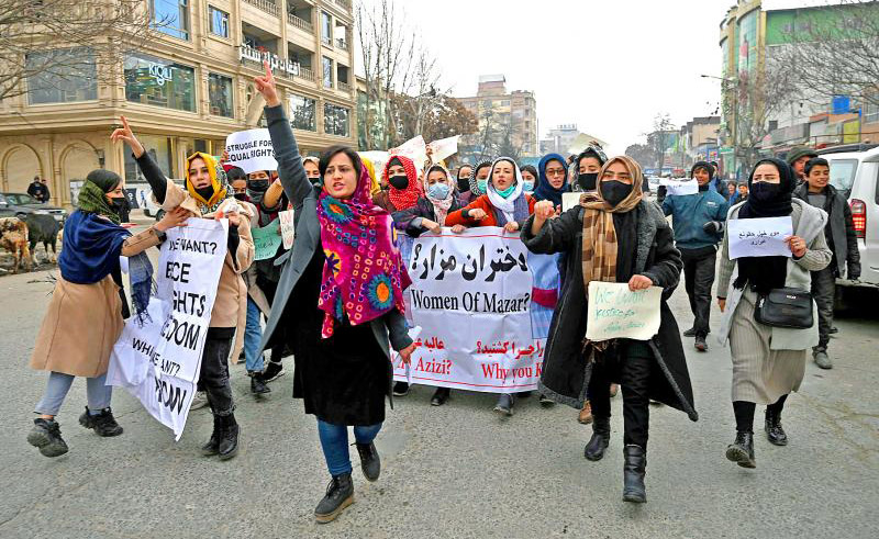 Afghan women chant slogans and hold banners during a women's rights protest in Kabul