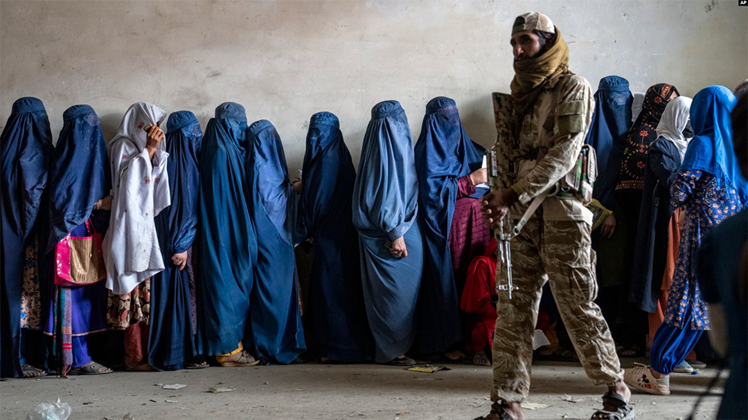 Afghan women in burqa waiting to get aid