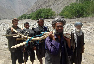 Afghan villagers transport the body of a victim after a flashflood landslide in Baghlan province