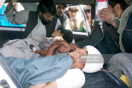 Injured Afghan children are attended to by medical personel as they are taken to hospital from the scene of a bomb blast which killed at least 15 people, mostly children