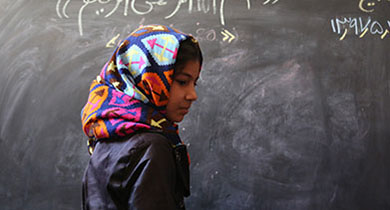 10-year-old Fatima is on the board to solve a math question in Herat, Afghanistan