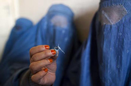 An Afghan woman holds up opium as she attends a counseling session at the Nejat drug rehabilitation centre