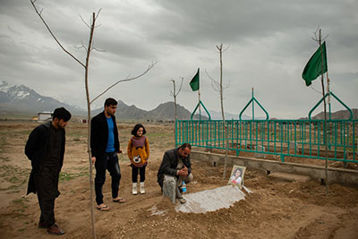 Murtaza Ahmadi, right, with family members at the grave of his daughter Mahsa