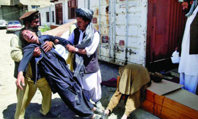 Afghans help a man mourning his brother's death, south of Kabul