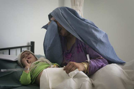 An Afghan woman, Bibi Hur, cries over her injured daughter at a hospital in Herat