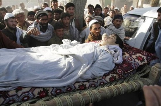 Relatives look at the body of an Afghan school boy