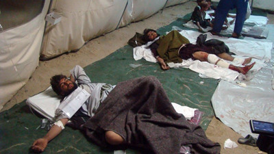Wounded Afghani men and children lie on the ground in a tent after a deadly attack targeted a checkpoint, in Lashkar Gah, capital of the southern Helmand province, Afghanistan