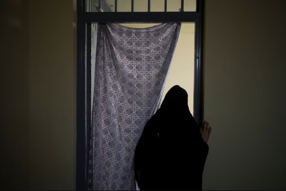 Woman in Afghanistan Looking Through a Window